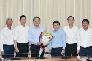 市人委會主席阮成鋒向市人委會原副主席黎文科（左三）頒發按願望辭職的《決定》。（圖源：阮黎）