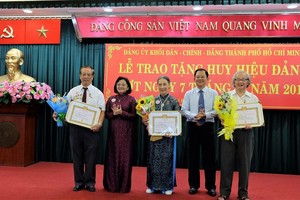 市委宣教處主任申氏舒（左二）向老前輩黨員頒授50年黨齡紀念章。