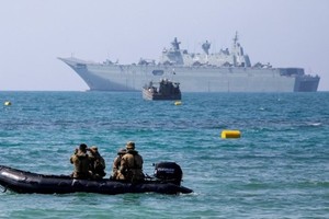 澳洲海軍兩棲攻擊艦阿德萊德號（後）抵達莫爾茲比港。（圖源：互聯網）