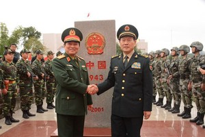 我國國防部長吳春歷大將（中左）與中國國防部長魏鳳和上將在越中邊境943(1)號界碑之處合照。（圖源：仲海）