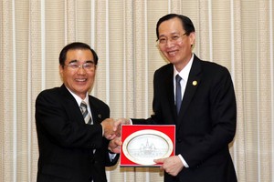 市人委會常務副主席黎清廉（右）向日本鹿兒島市市長森博幸贈送紀念品。（圖源：越通社）