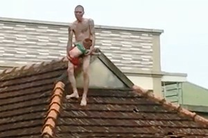 癮君子抱著兩歲的兒子爬上房頂不斷大喊大叫。（圖源：H.Tâm）