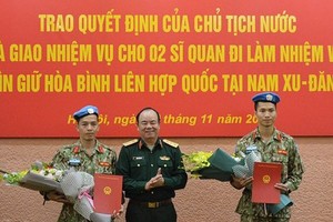 越南人民軍隊副總參謀長范玉明上將（中）向陳德享少校和阮福東大尉轉交國家主席的《決定》。（圖源：黃宇）