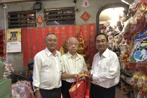 副會長黃炳友（左）、許永成（右）贈送禮物給楊光澤校友。