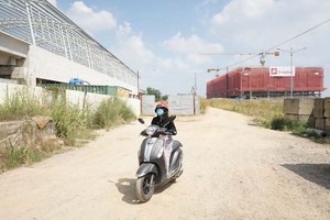 進出新東區車站的街道每逢車輛駛過就彌漫著塵土。