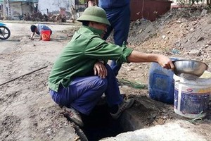 民眾在排水渠撈油。（圖源：陳毅）