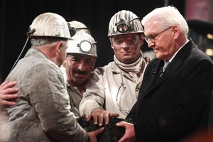 煤礦工人在現場象徵性地挖出最後一塊硬煤，交到德國總統施泰因邁爾（右）手中。 （圖源：AFP）