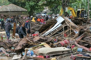 災民在受海嘯破壞的房屋內檢查被困者。（圖源：互聯網）