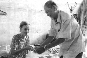 阮功化老大伯向獨居的阮氏蘭老婆婆送飯。