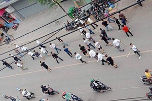 手持棍棒的一群青年在馬路上橫行。（圖源：秋苑）