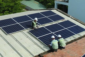 電工在給“五‧一五”學校安裝太陽能電池板。