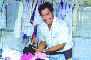 阮先生在自己的免費舊衣服攤內。