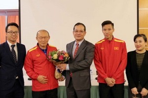 阮廷操大使（左三）向國足隊韓籍主教練朴恒緒贈送鮮花。（圖源：互聯網）