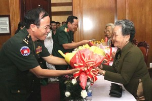 柬埔寨王家軍隊第二軍區副司令Sun Sumon中將（左）向越南英雄母親黎氏雪梅贈送鮮花。（圖源：春區）