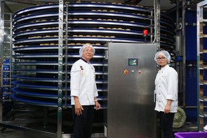 亞洲餅家總經理高肇力(左)視察全自動設備的生產情況。