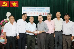 本報編委兼編輯部主任范興(中)接受王永勝理事長(左三)的捐款。