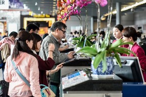 旅客在櫃台辦理登機手續。（圖源：新華社）