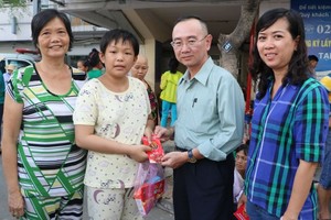 本報編委兼編輯部主任范興(右二)向患上腦腫瘤的華人病童陳雅珍贈送禮物代金。