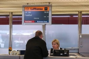 圖為在德國首都柏林的泰格爾機場，一名旅客在漢莎航空公司櫃檯辦理乘機手續。（圖源：新華社）