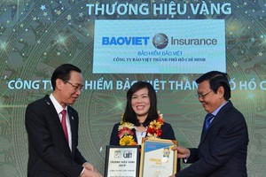 市人委會常務副主席黎清廉（左）與《西貢解放報》總編輯阮晉豐向企業頒獎。（圖源：越勇）