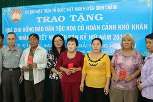 范興主任與許氏芳紅副主席向華人貧困戶贈送利是。