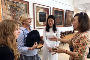 本市畫家向外賓介紹畫展。