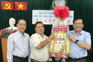 丁文森(左二)和羅煥民(左一)向本報賀年。