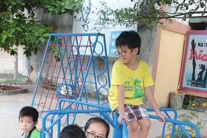 兒童們在寬闊和綠樹成蔭的青年公園裡高興地玩耍。