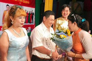 第六郡婦聯會主席梁青竹向華人熱心人士贈花致謝。