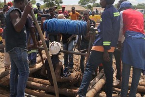 2月15日，在津巴布韋西馬紹納蘭省，救援人員在一座被洪水淹沒的金礦展開營救。（圖源：互聯網）
