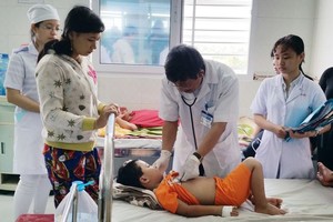 醫生在為患登革熱病童診斷。（圖源：阮行）