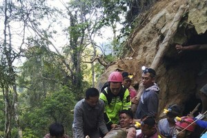 救援人員運送被救起的倖存者。（圖源：AP）