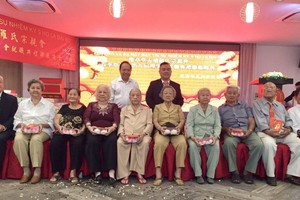 羅志榮理事長(後排右一)向長者贈送禮物。