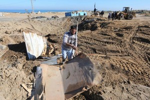 3月9日，在加沙地帶南部城市汗尤尼斯，人們清理空襲現場。（圖源：新華社）