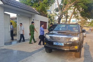 公安部調查隊的汽車停在峴港市財政廳原廳長阮清創的私寓前下車走進大門進行搜查。（圖源：VTC News）