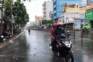 本市昨中午局部降雨。圖為在新富郡壘半碧街上遇到的一場陣雨。（圖源：光凱）