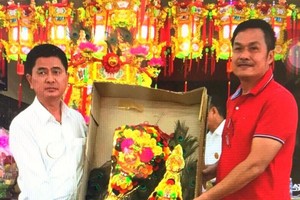 陳昶霖(右)向陳良轉交“大紅金花。