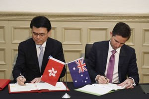 邱騰華在澳洲悉尼與澳洲貿易、旅遊和投資部長伯明翰（右）簽署香港與澳洲《自由貿易協定》和《投資協定》。（圖源：香港政府新聞網）
