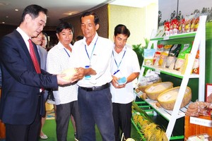 越南企業代表向中國駐本市總領事吳駿介紹農產品。