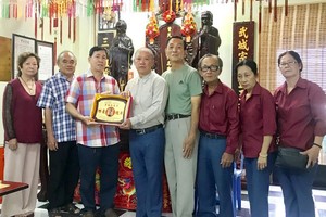 曾文良（左三）接受鄭成龍（左四）贈送紀念章。