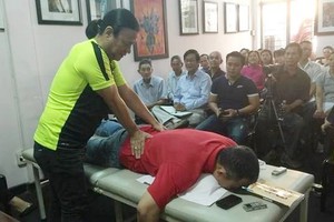 劉劍昌師傅向群眾示範舒緩高齡人腰椎疼痛推拿法。