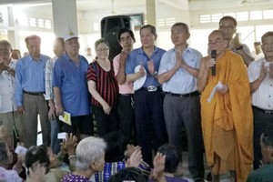 培德精舍慈善工作組在清涼寺給貧民贈送救濟品。