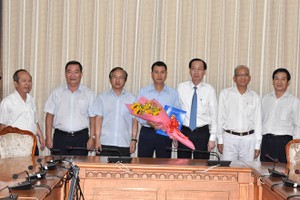 新任第二郡人委會副主席阮白黃鳳（中）接過人事委任《決定》和鮮花祝賀後與市領導合照。（圖源：Đ.Quân）