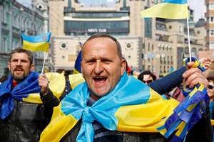 烏克蘭街頭披着國旗的民眾。（圖源：路透社）
