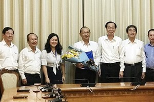 市人委會常務副主席黎清廉(右三)向阮春水同志(中)頒發退休《決定》。（圖源：孟和）