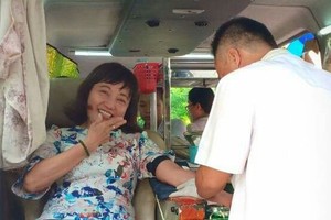 華人女幹部周金鳳正在捐血。