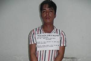 非法運輸軍槍者阮曰孟與被查獲的槍支及子彈。（圖源：德勝）