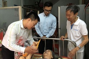 龍圖同志（右一）生前接待前來探望臥病在床的老伴劉桂同志的親友。