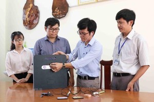 西原大學自然科學與技術系講師陳國霖（右二）、宗室長南（左二）和同事們向記者介紹“高科技作弊設備探測器”的功能。（圖源：越通社）