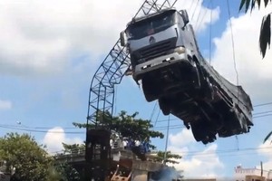 起重機吊起卡車時吊臂突然彎折的一剎那畫面。（圖源：視頻截圖）